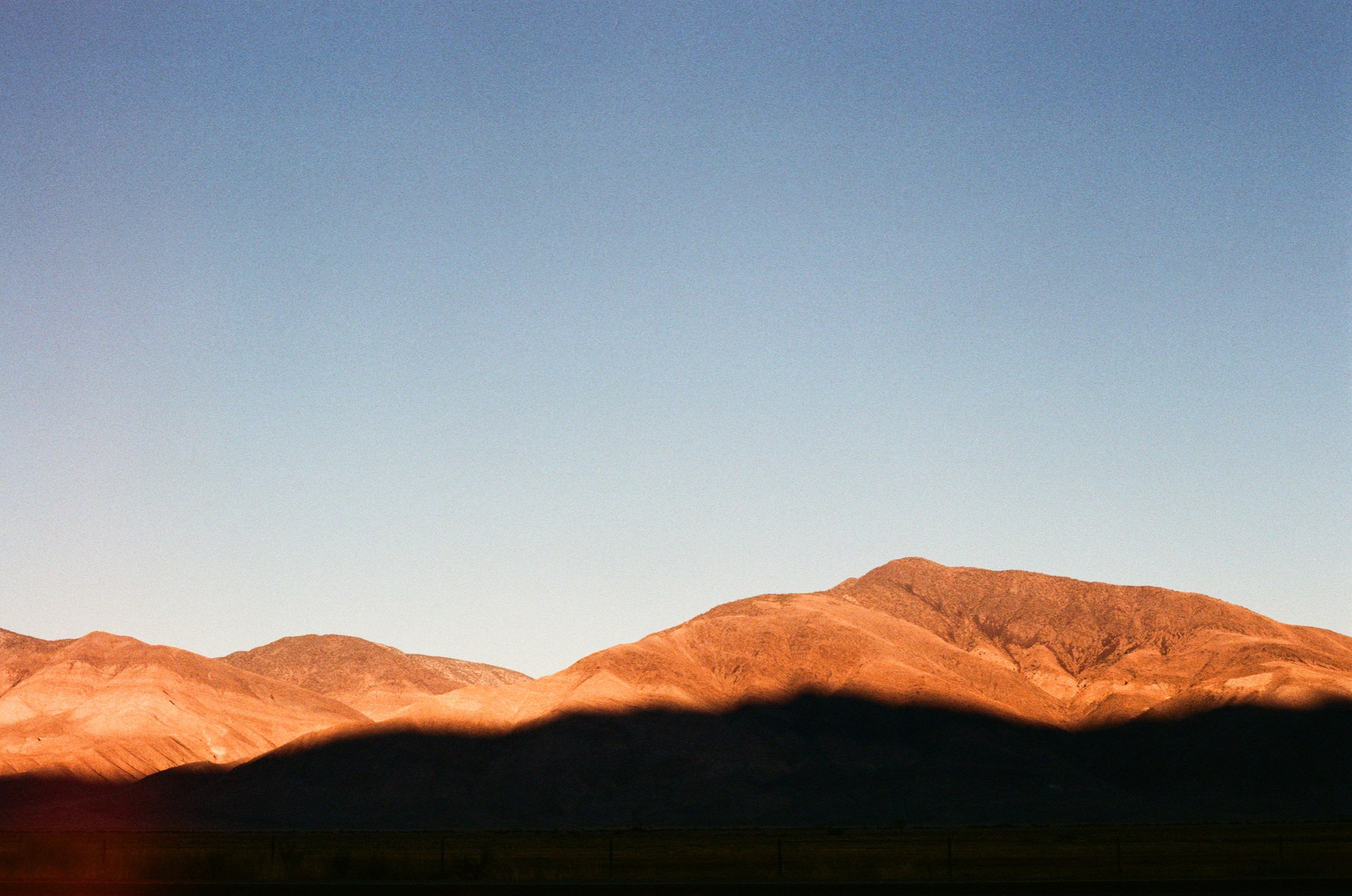 Low sun lighting a ridge of bare hills