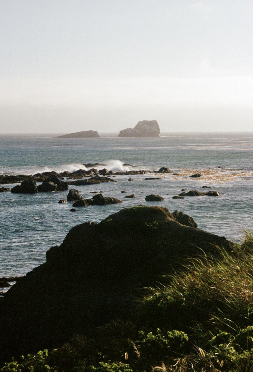 A rocky coastline with sea stacks offshore